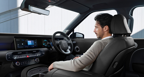 A man relaxing comfortably in the all-new PALISADE during STAY Mode