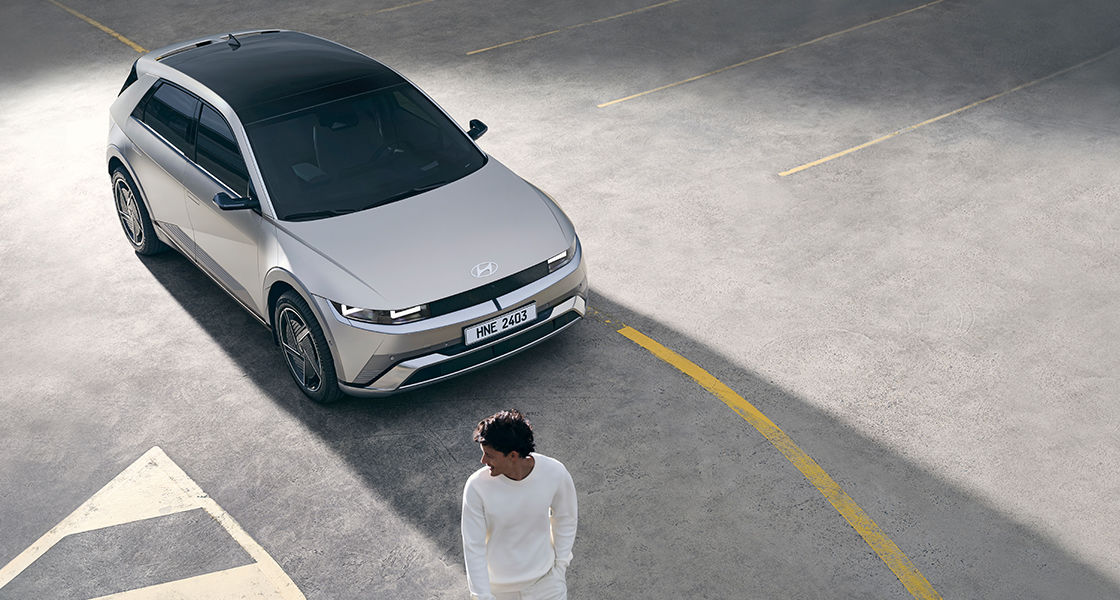 'A man is walking in front of the vehicle