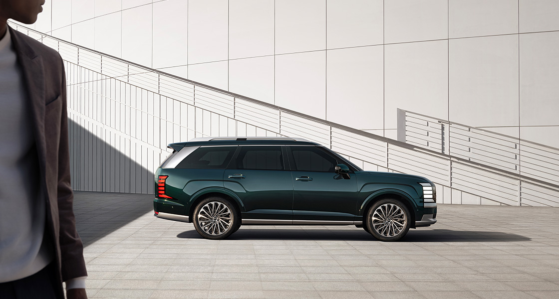 The all-new PALISADE side view, in front of a white minimalistic wall