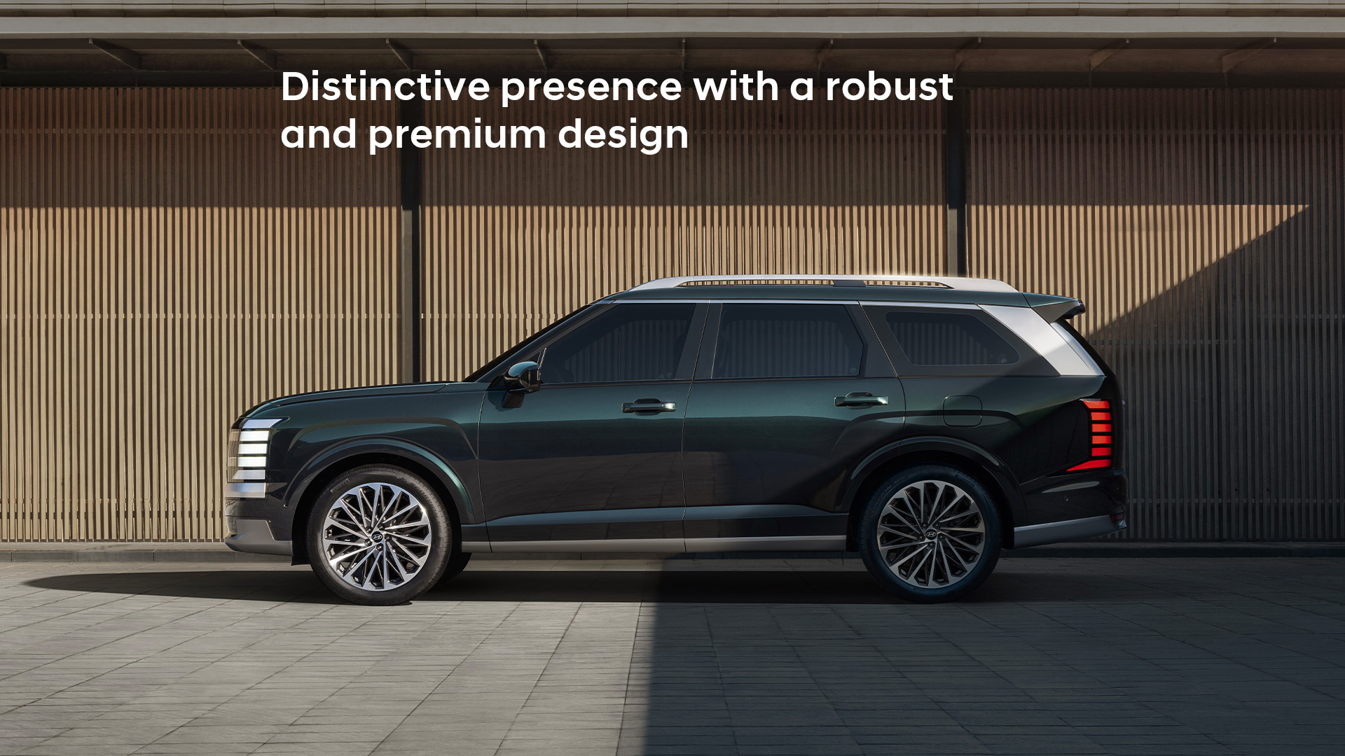 The all-new PALISADE side view, in front of a wall