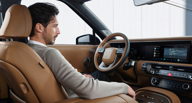 A man relaxing comfortably in the all-new PALISADE during STAY Mode