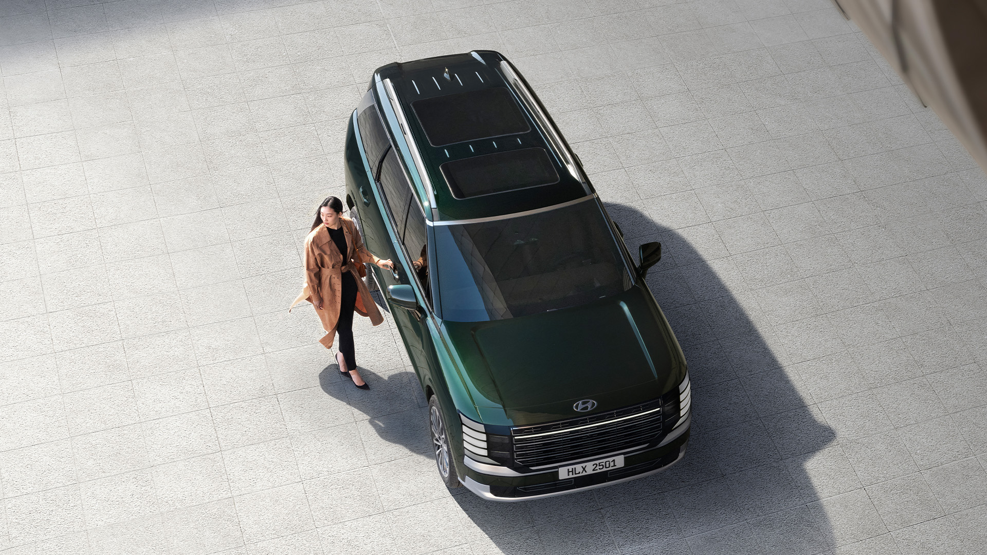 A woman standing next to the all-new PALISADE