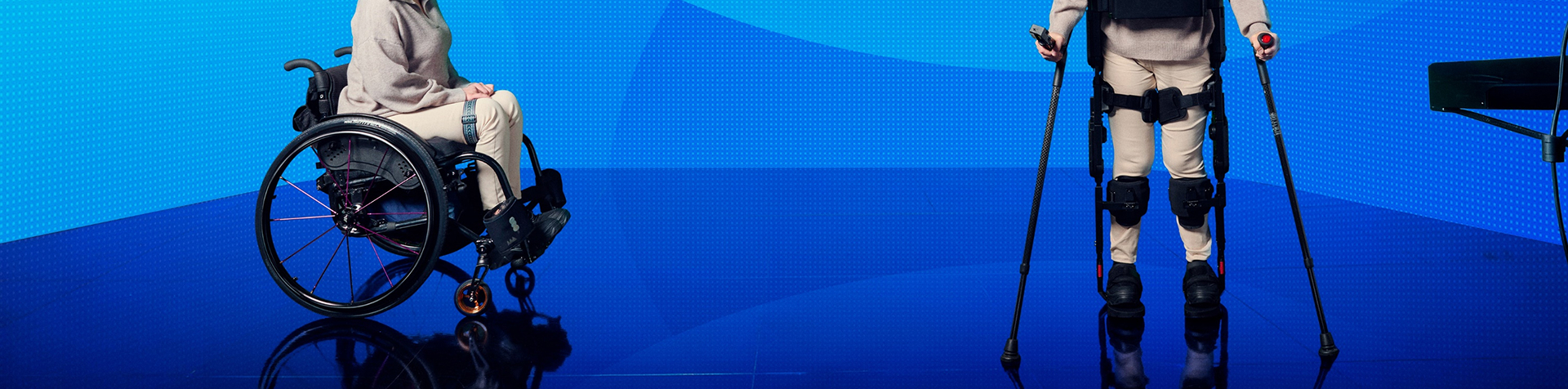 휠체어를 탄 여자와 의료용 착용로봇 X-ble MEX를 착용한 채 서있는 여자가 마주보고 있는 사진