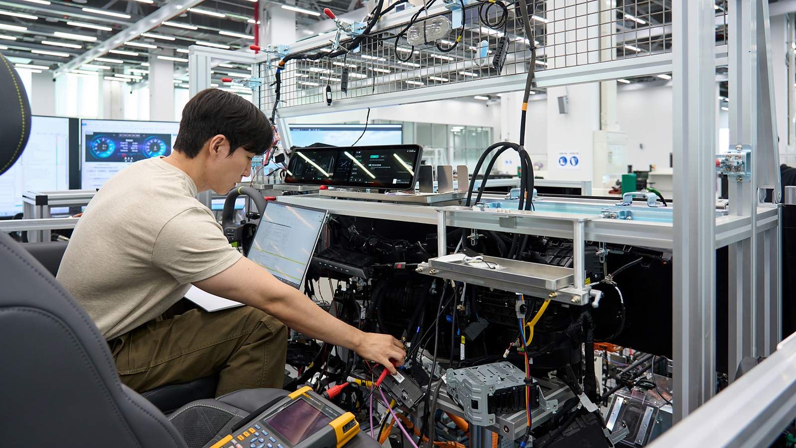 Engineer validates vehicle functions and electronic control systems using a full-scale wire-car test bench at NOVA Lab.